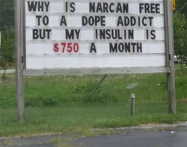 Steet Sign Asking "Why is NARCAN Free to a Dope Addict But My Insulin is $750 a Month"